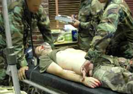 Figure 1:Military medics practice lifesaving procedures on an actor with simulated injuries.